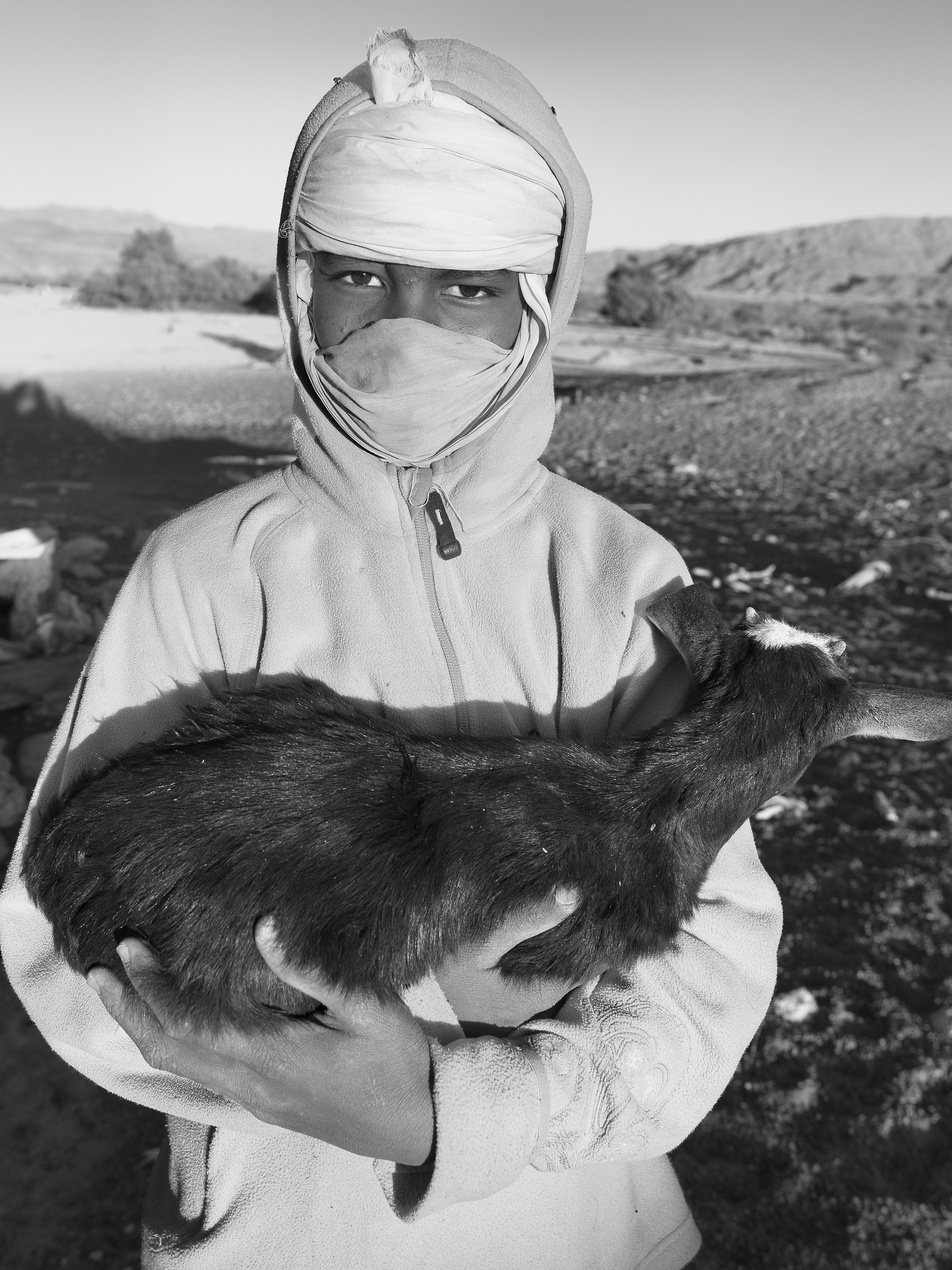 a man in a white outfit holding a cat