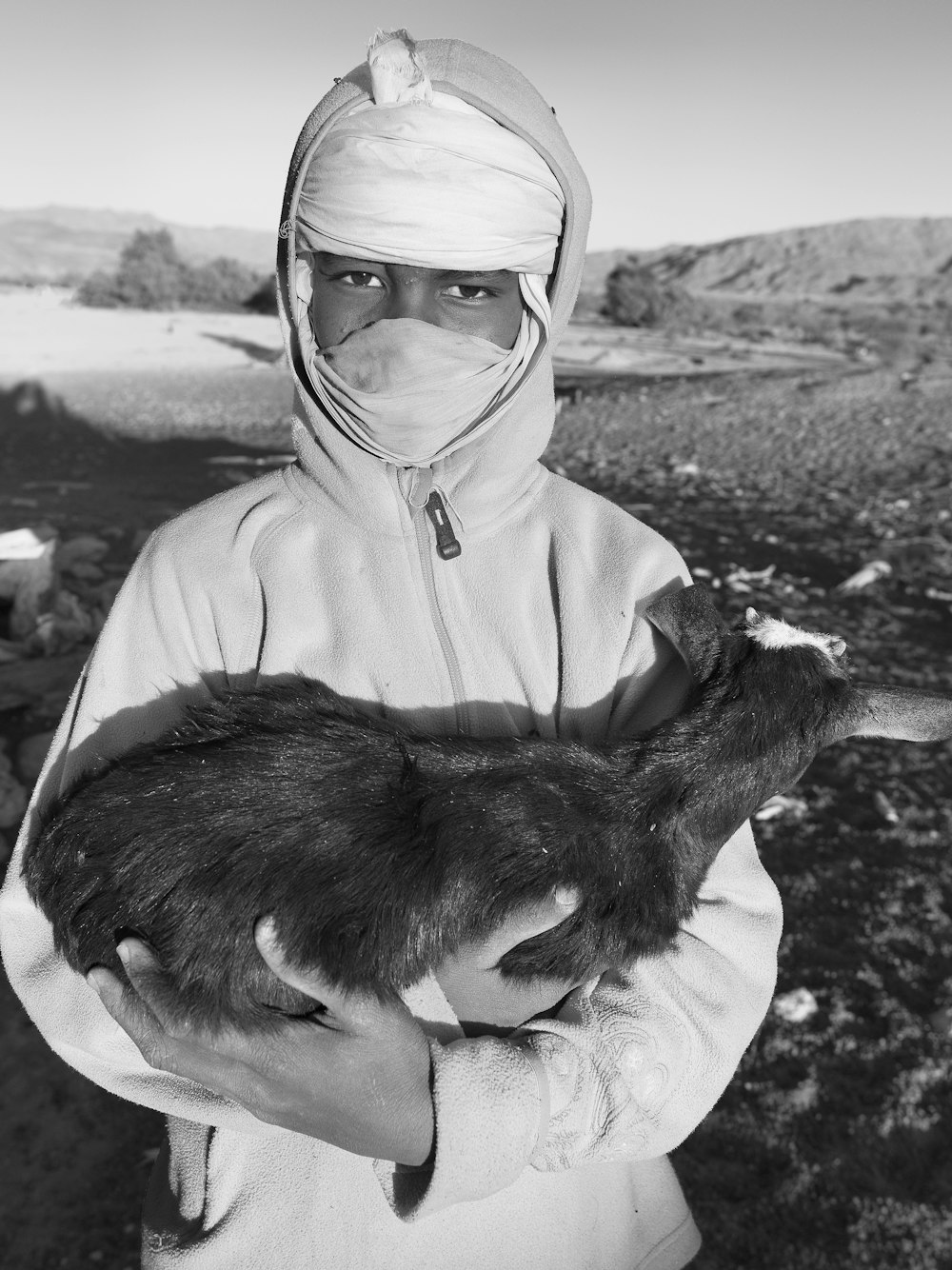 a man in a white outfit holding a cat