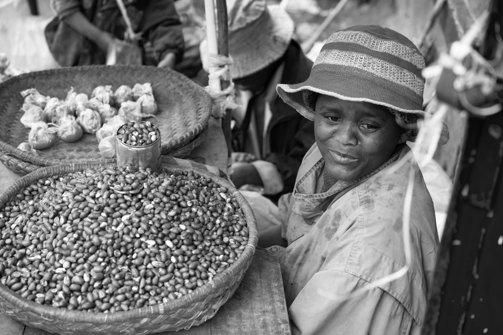uma foto em preto e branco de uma mulher vendendo comida
