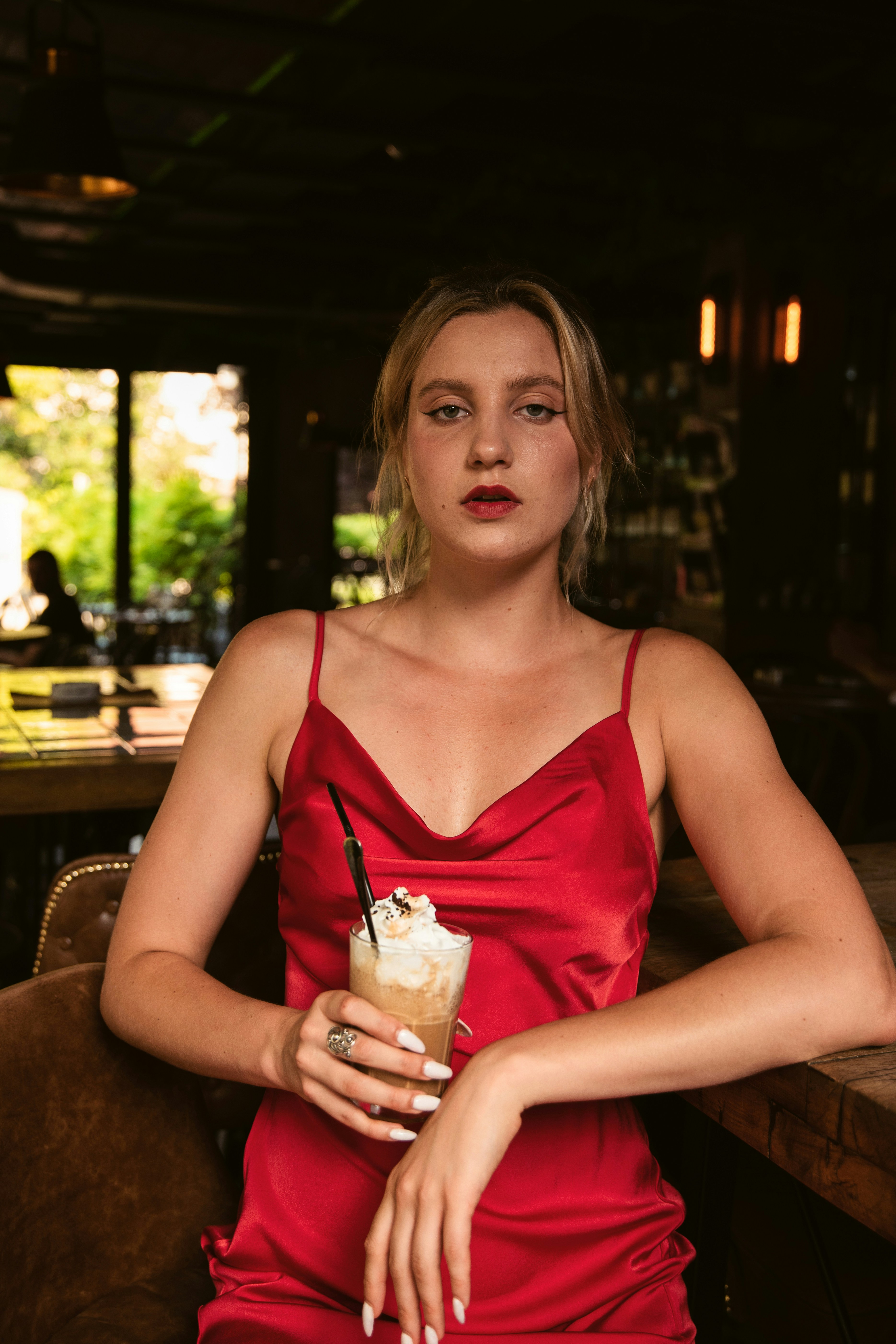 a woman in a red dress holding a drink
