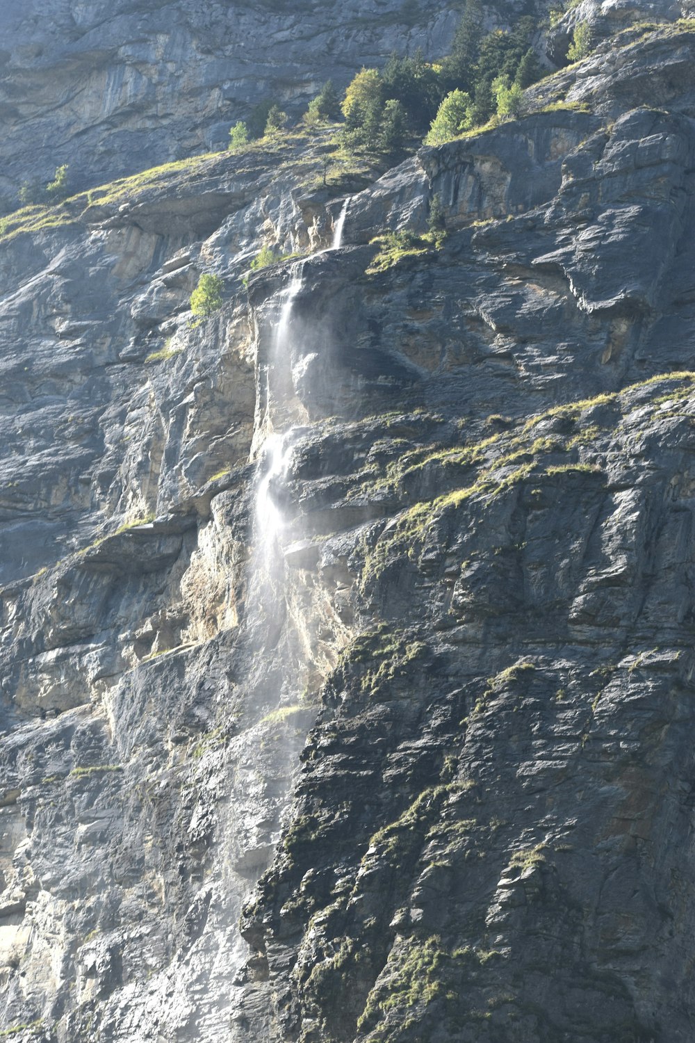uma montanha muito alta com uma cachoeira saindo dela