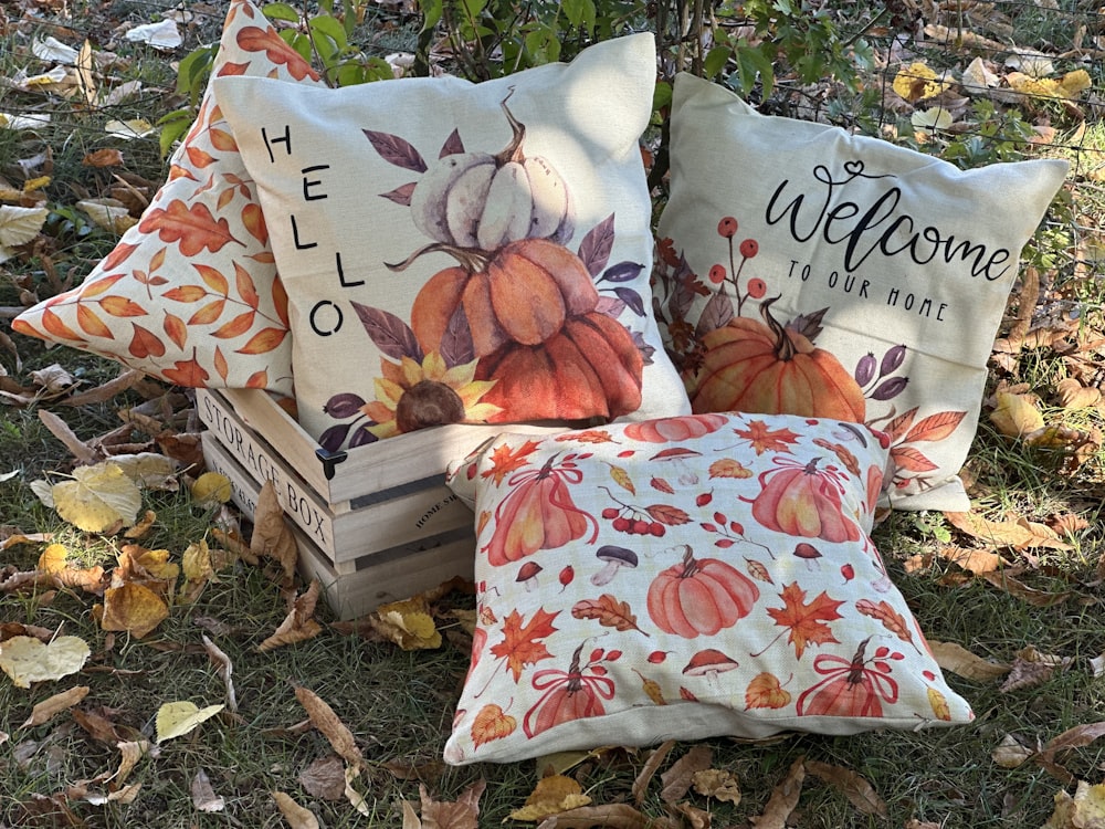 a couple of pillows sitting on top of a pile of leaves