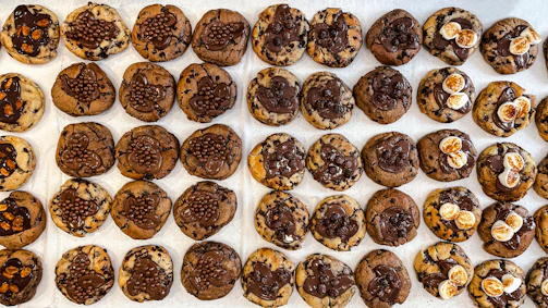 Rows of chocolate-dipped cookies with personalized designs and names for a graduation party.