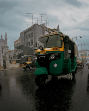 A Kinetic Green electric three-wheeler delivering goods in the bustling streets of Machilipatnam.