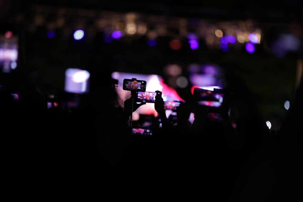 a group of people taking pictures with their cell phones