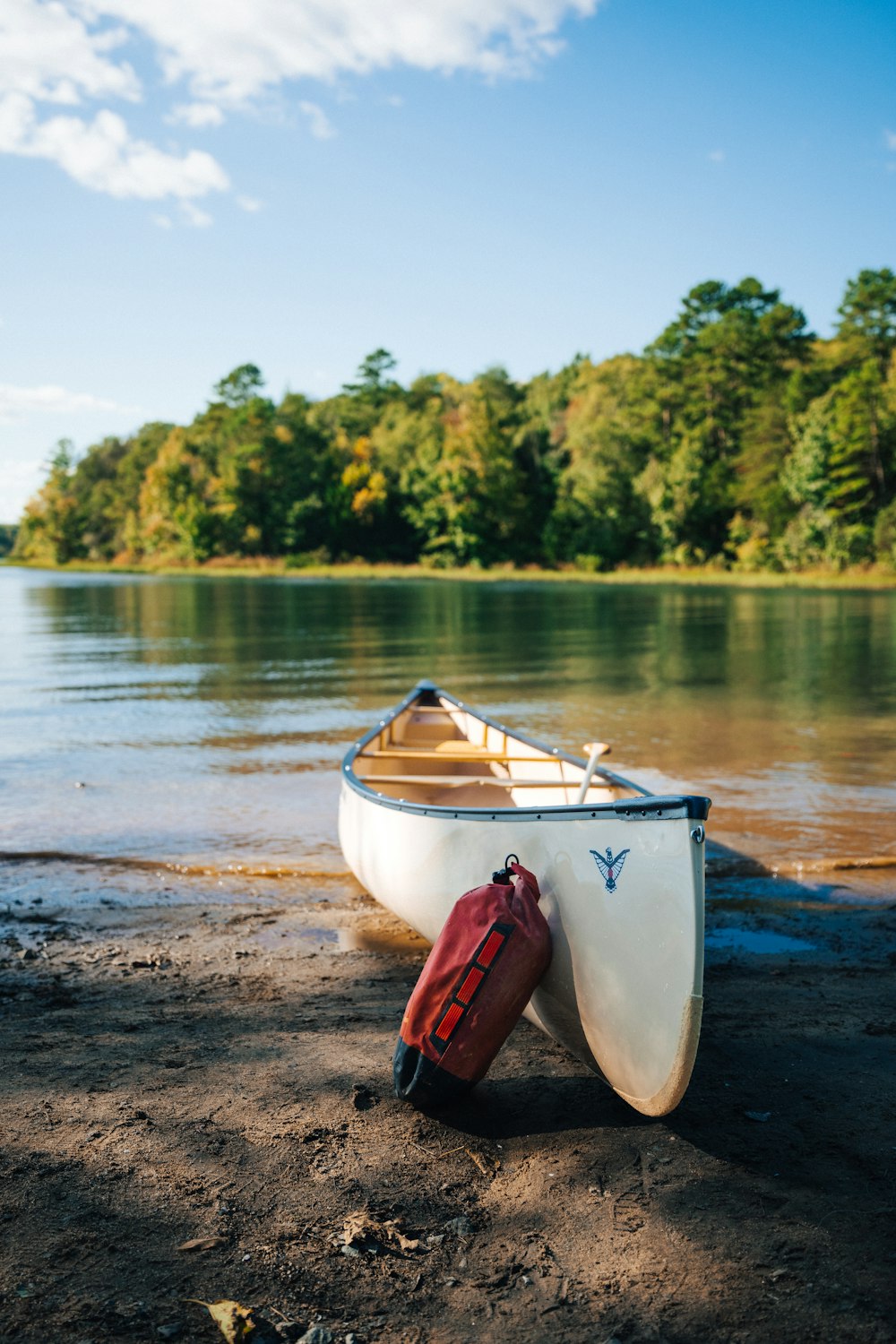 a small white boat sitting on top of a sandy beach