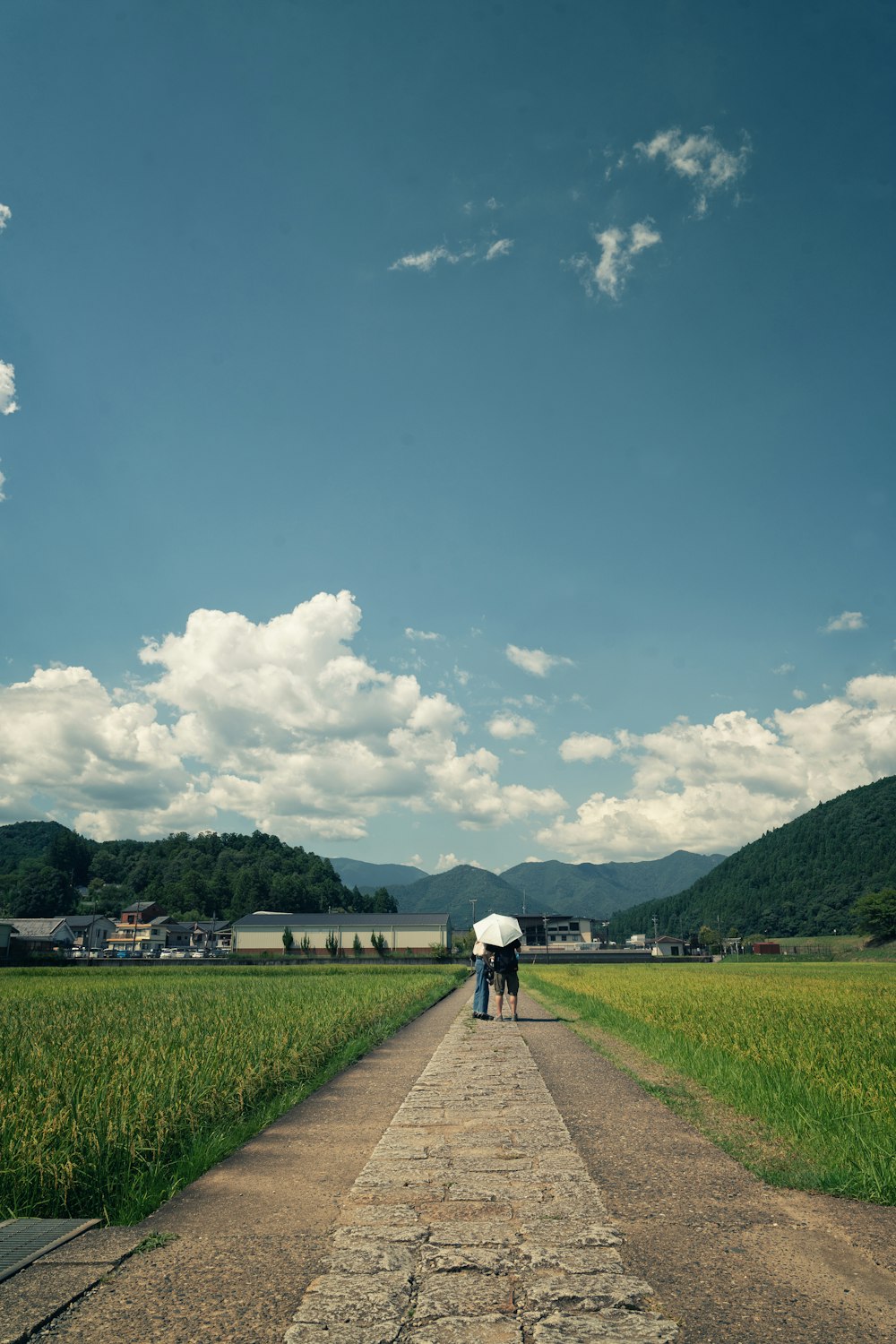 a couple of people standing on a dirt road