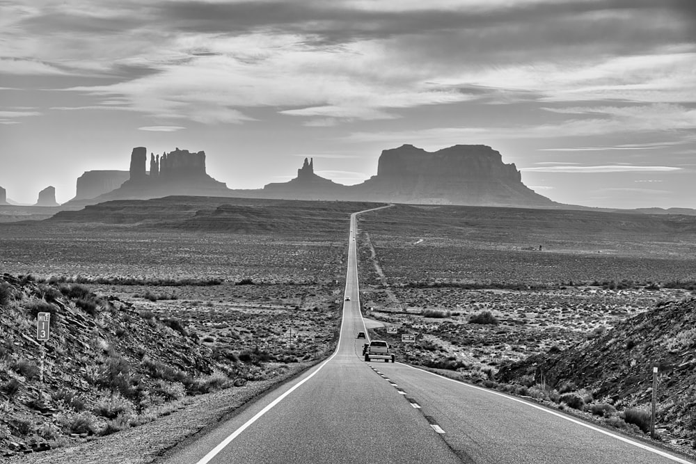 a black and white photo of a highway in the desert