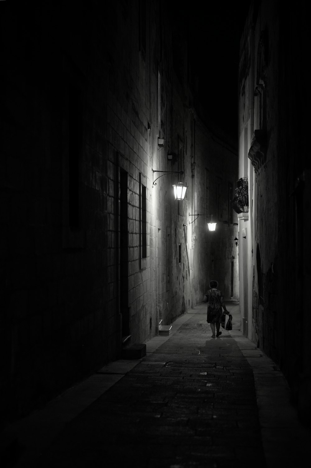 a person walking down a dark alley way