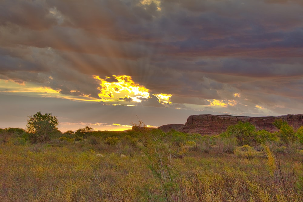 the sun shines through the clouds over the desert