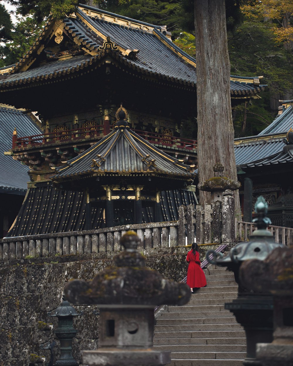 a woman in a red dress walking up some steps
