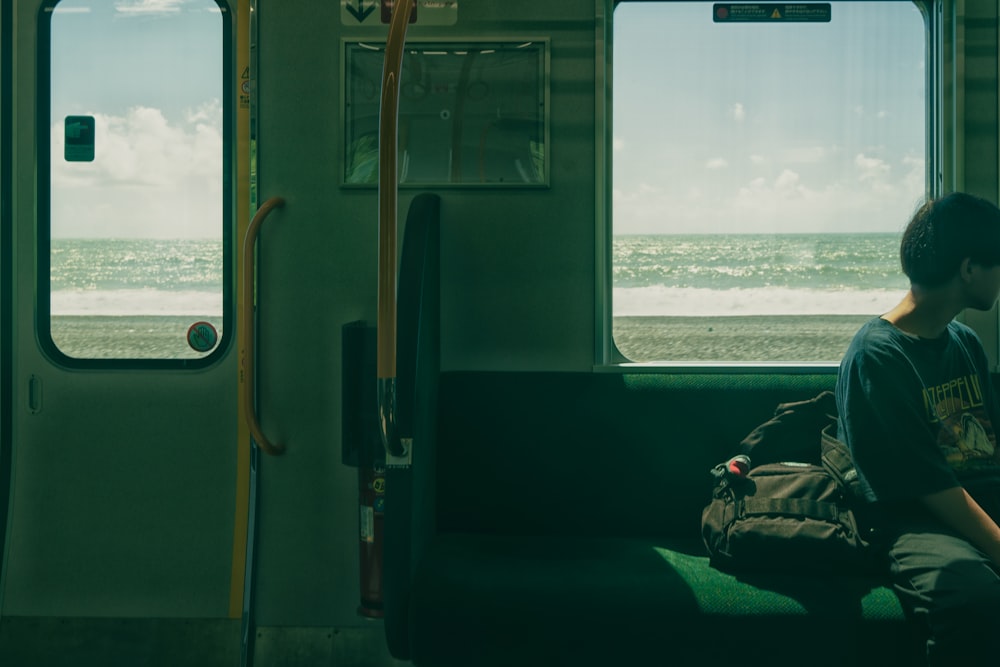 a man sitting on a train looking out the window