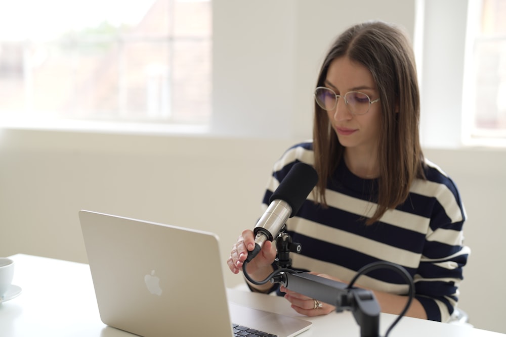 a woman sitting at a table using a laptop computer