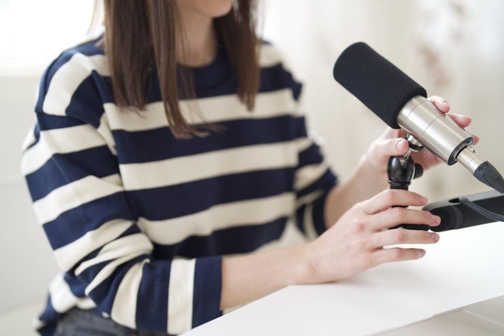 a woman in striped shirt holding a microphone