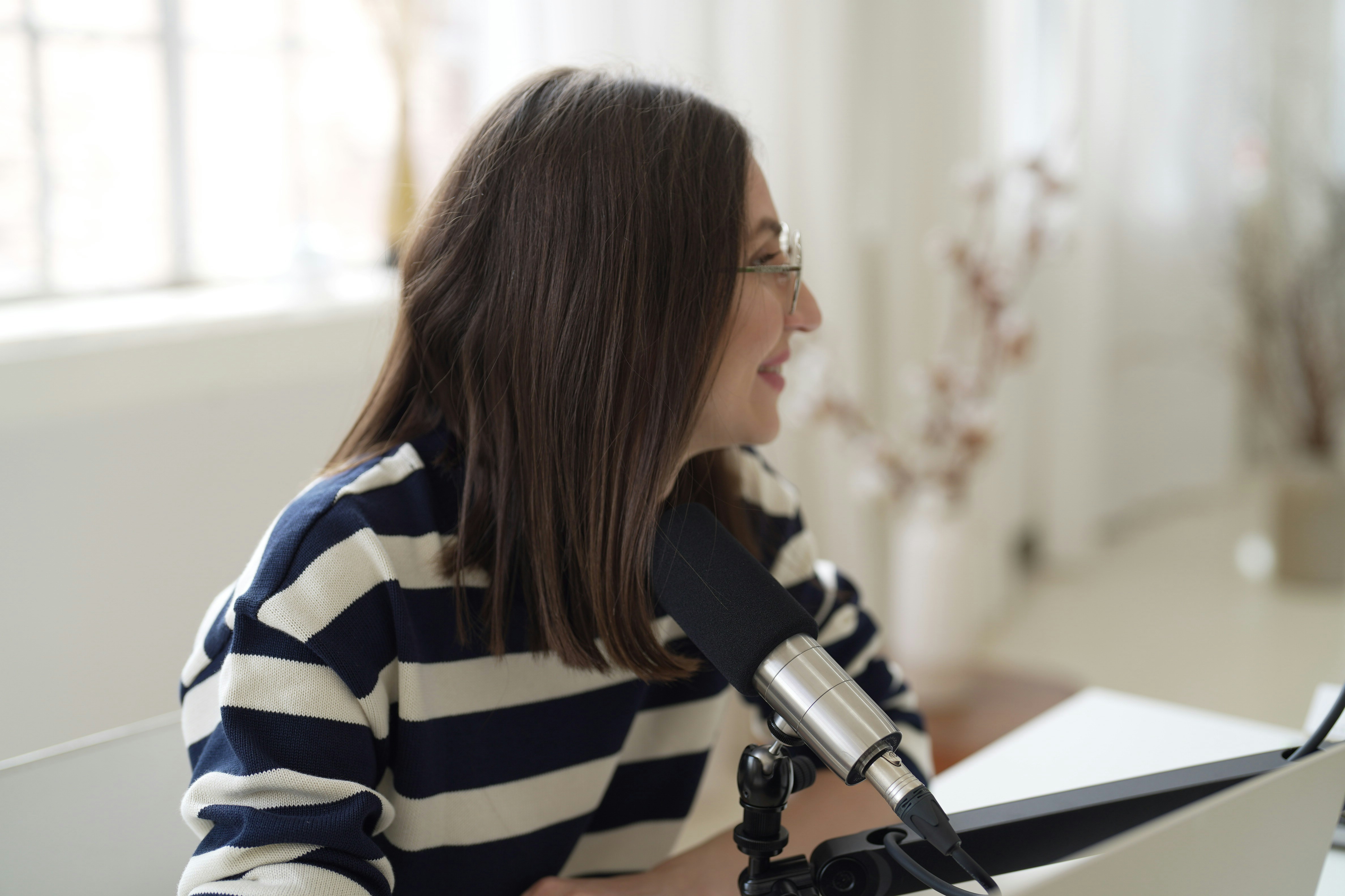 a woman sitting in front of a microphone