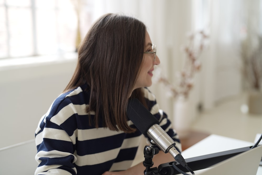 a woman sitting in front of a microphone