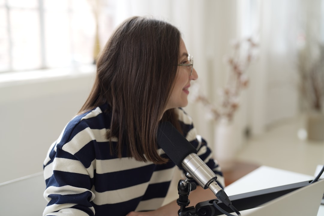 a woman sitting in front of a microphone, Female streaming from her home office using an XLR condenser microphone for he