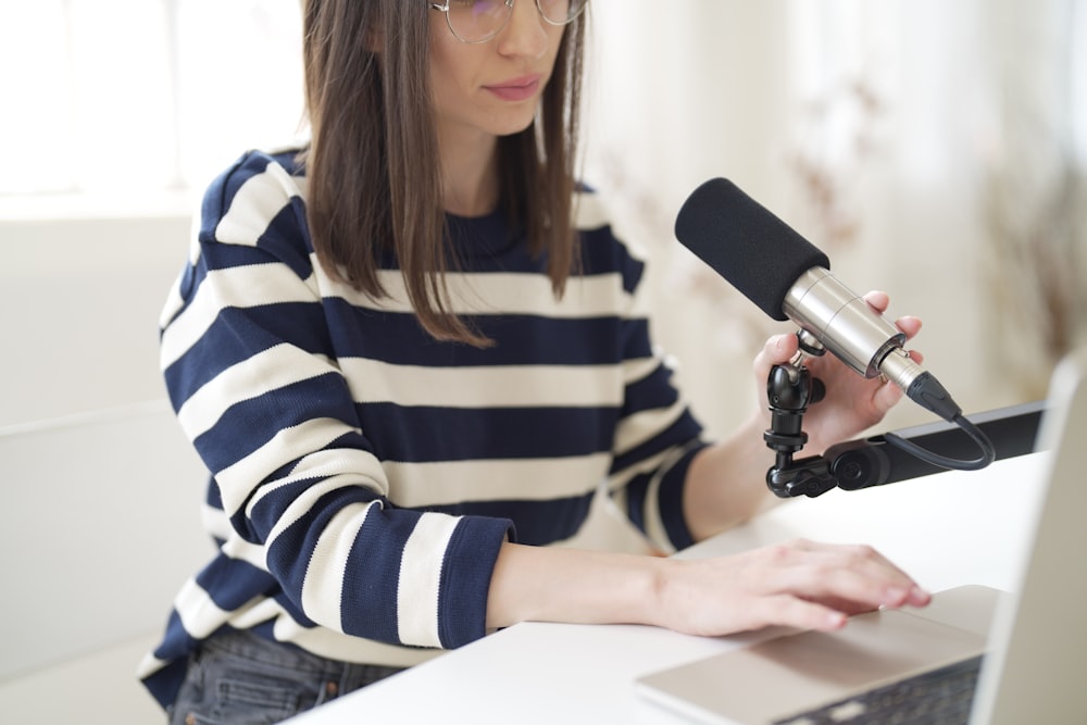 a woman sitting at a desk with a microphone in front of her