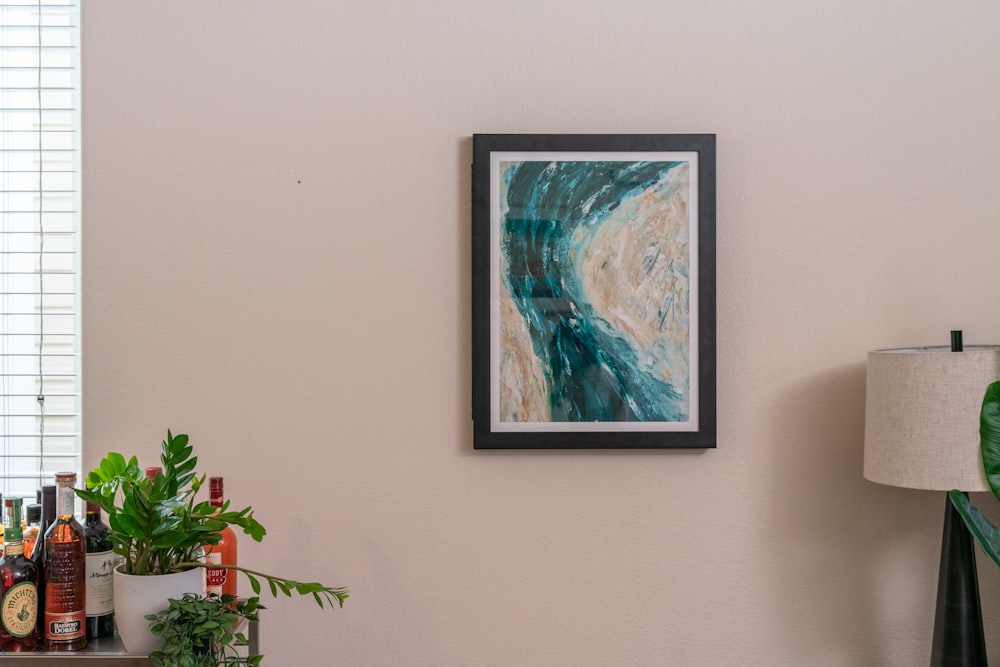 a painting hanging on a wall next to a lamp