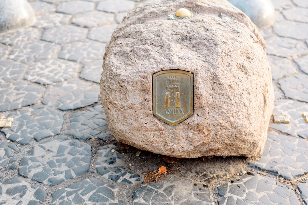 a rock with a plaque on it sitting on the ground