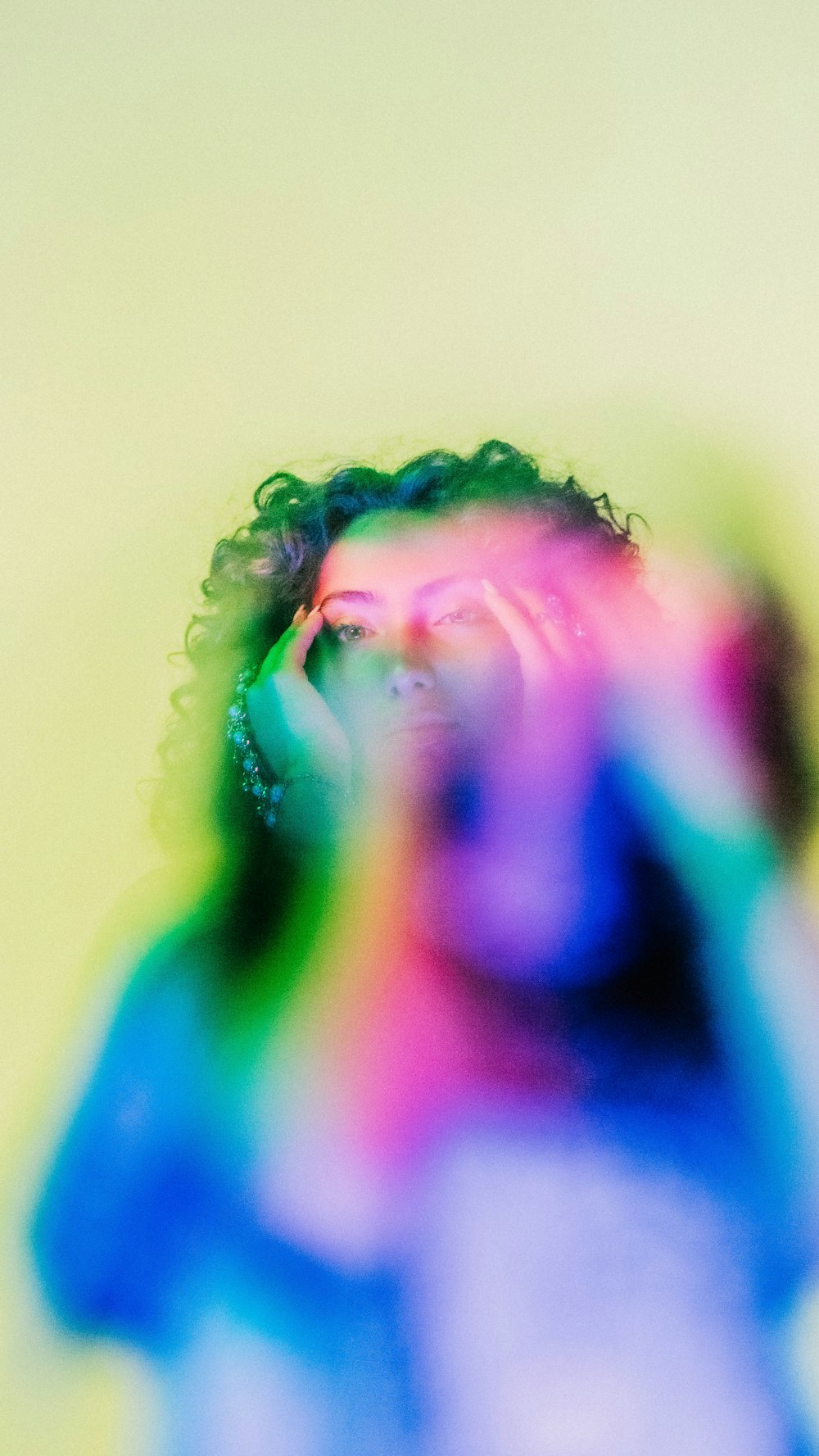 a man with a multicolored shirt covering his face