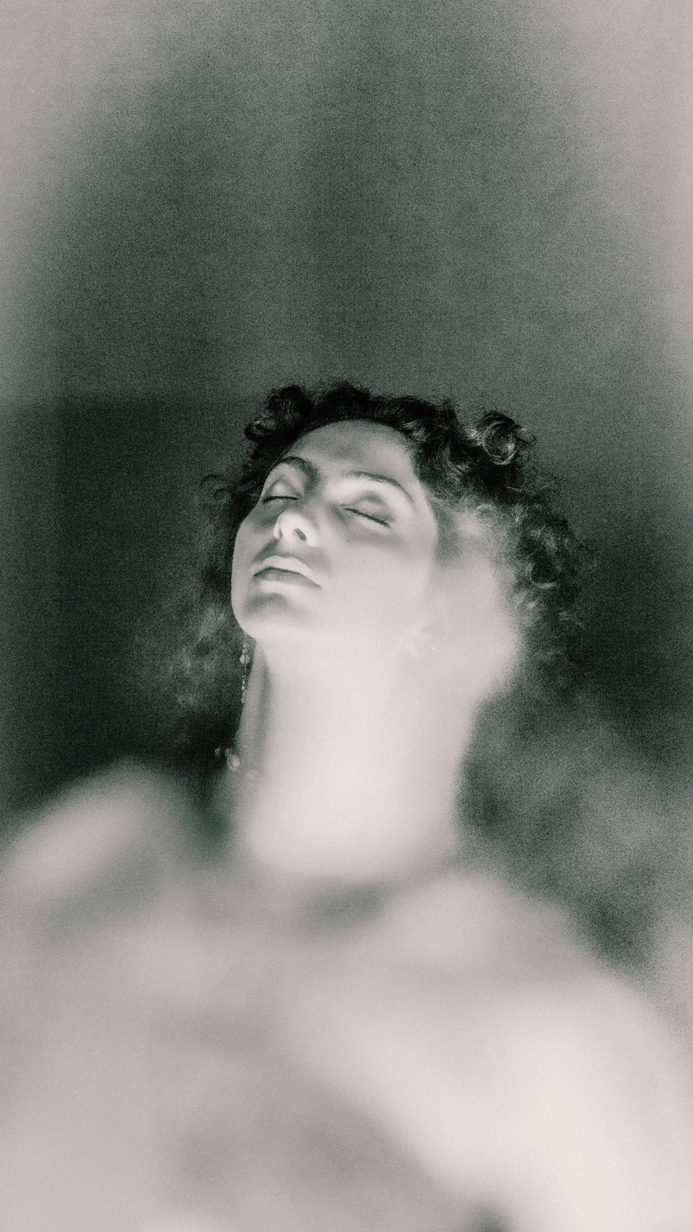 uma foto em preto e branco de uma mulher de olhos fechados