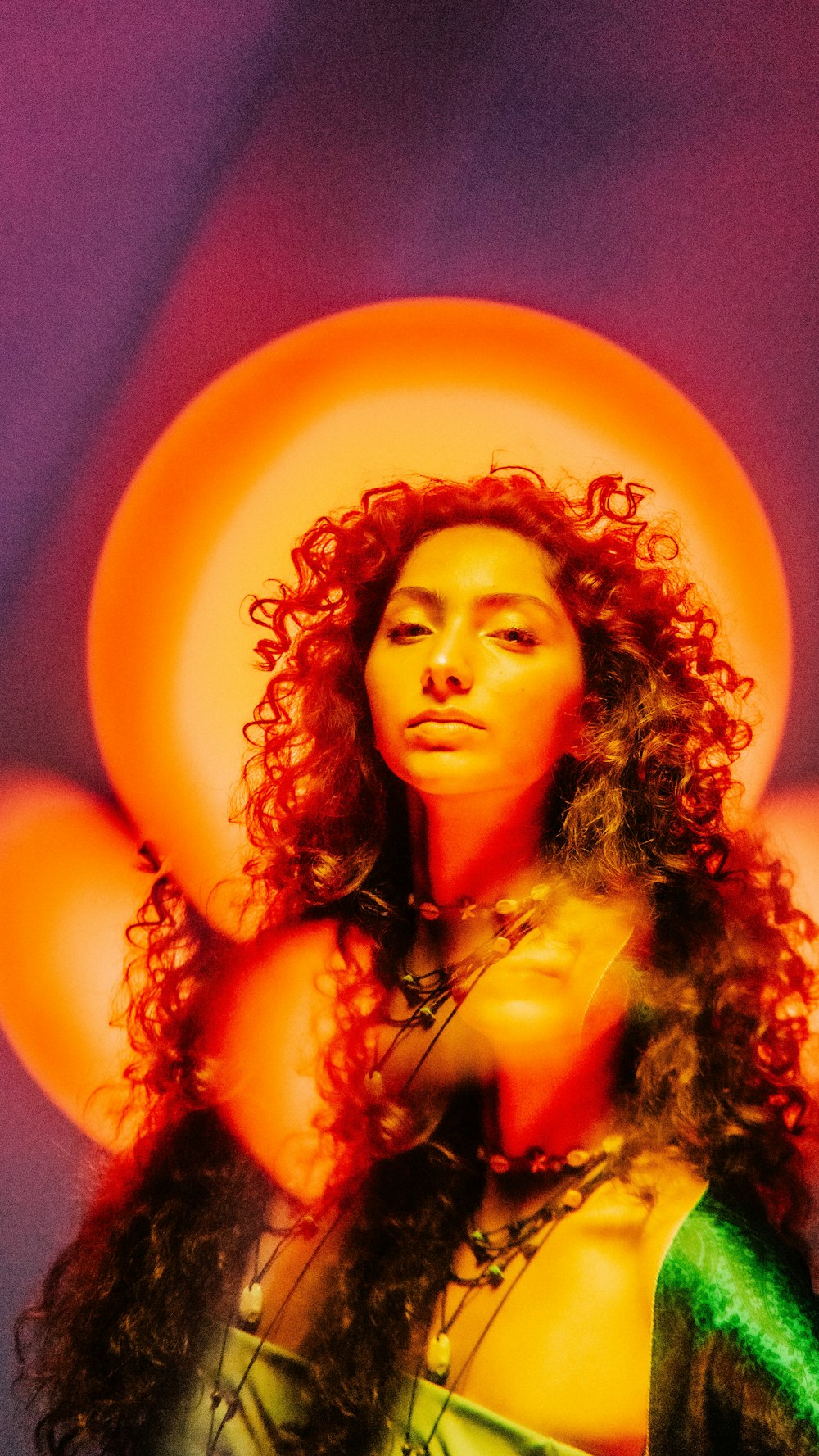 a woman with curly hair wearing a green dress