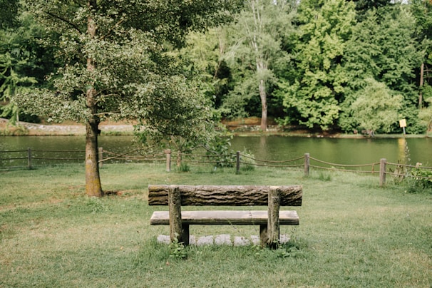A peaceful outdoor scene with a journal and pen resting on a bench, inviting reflection.