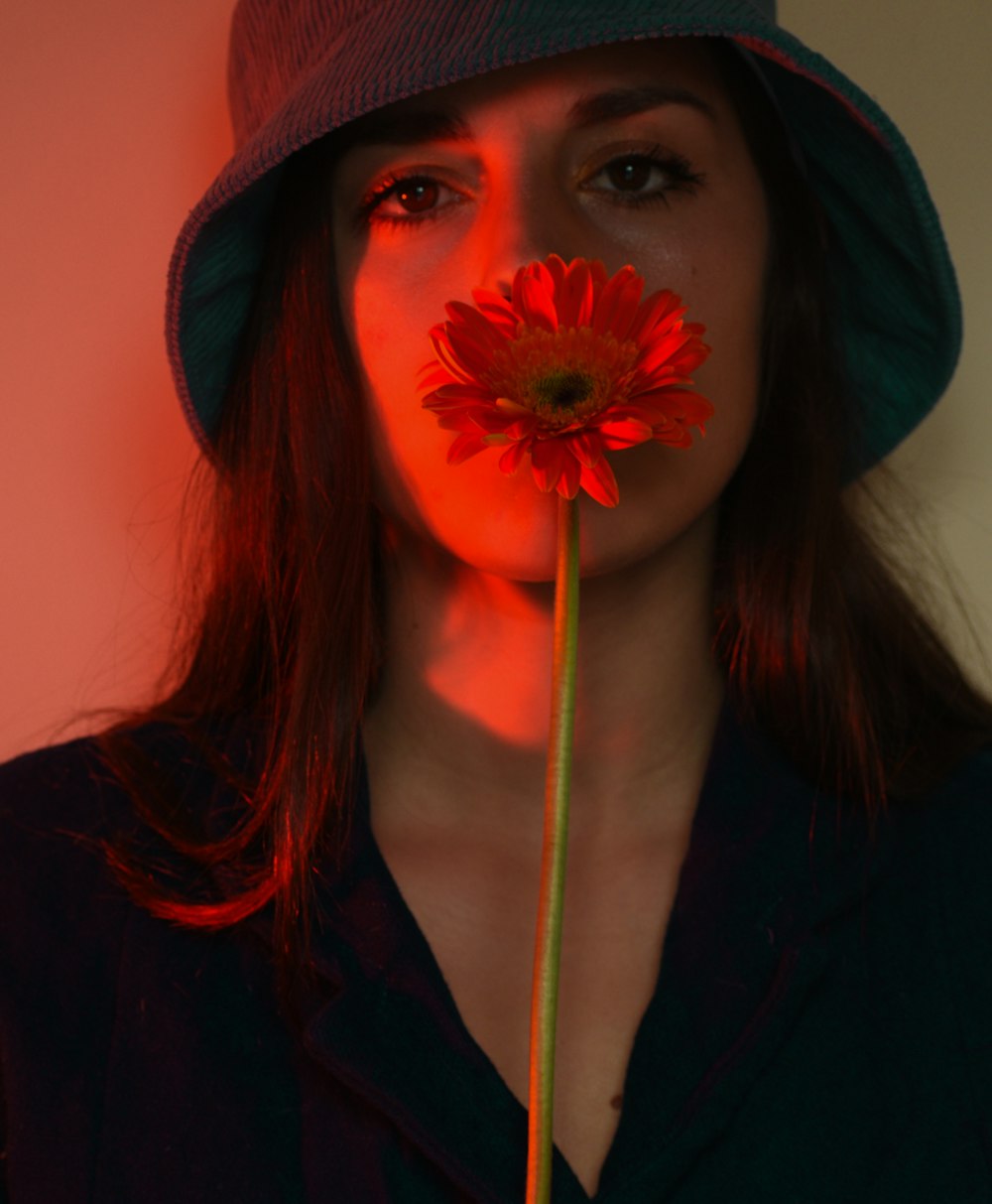 Una mujer con una flor en la boca