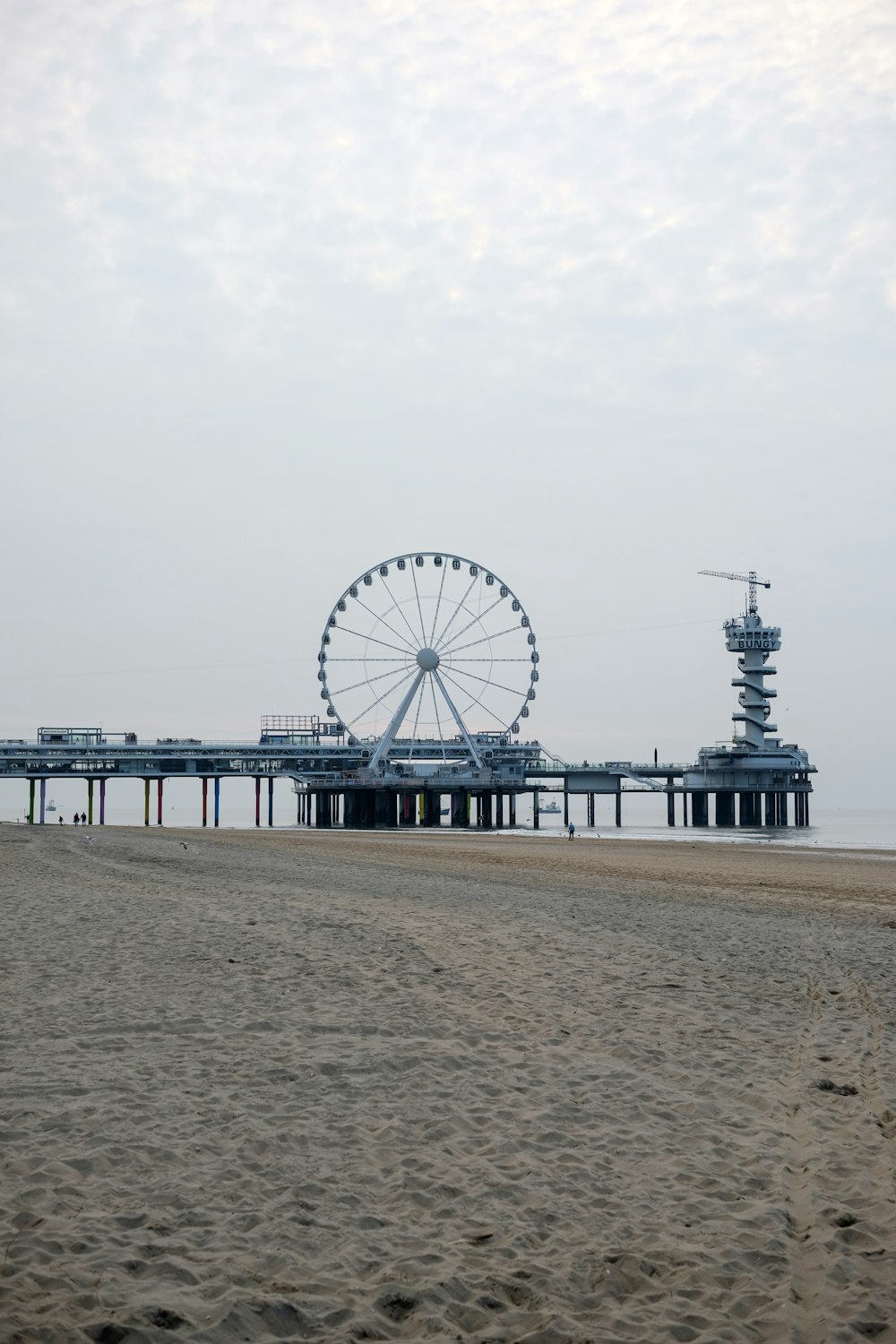 a ferris wheel sitting on top of a sandy beach