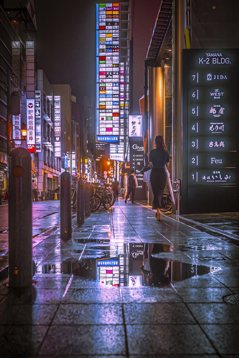 a person walking down a city street at night