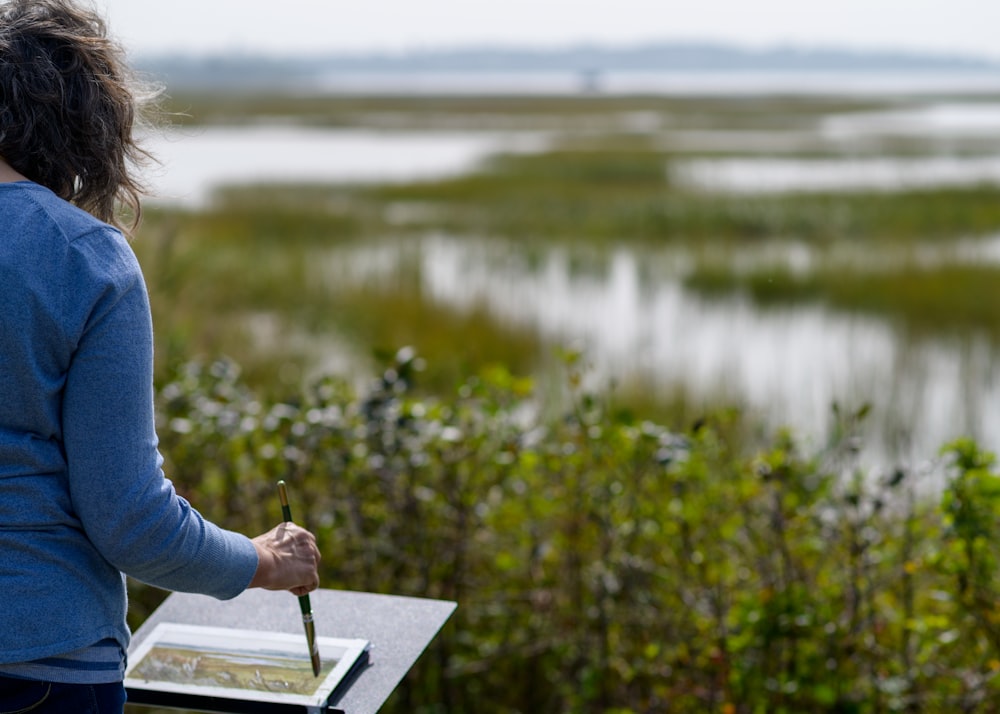 a woman holding a pen and writing on a piece of paper