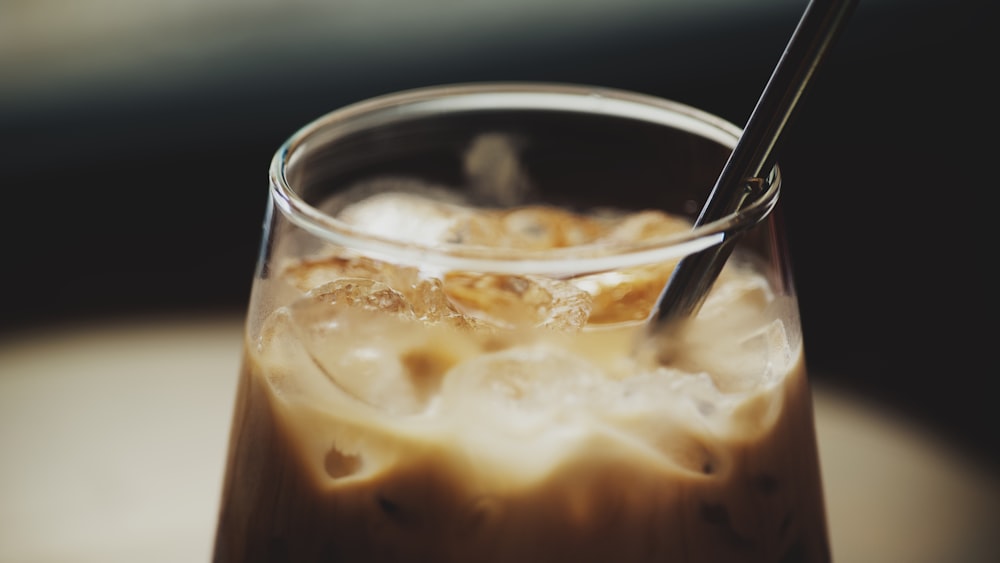 a glass of iced coffee with a spoon in it