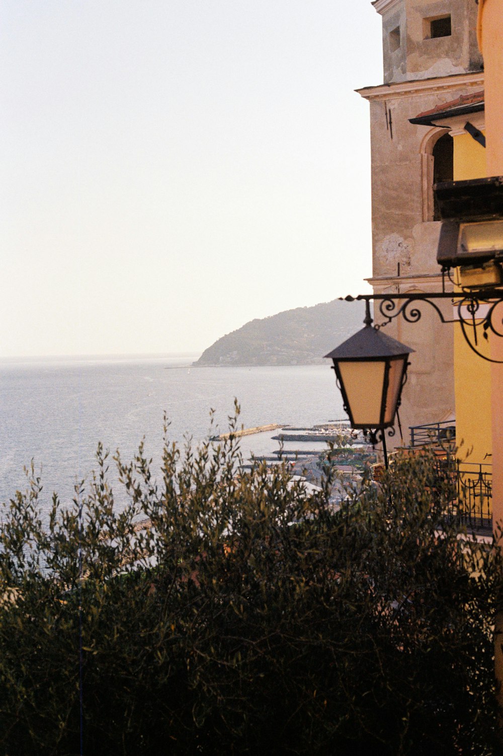 a street light sitting next to a building near the ocean