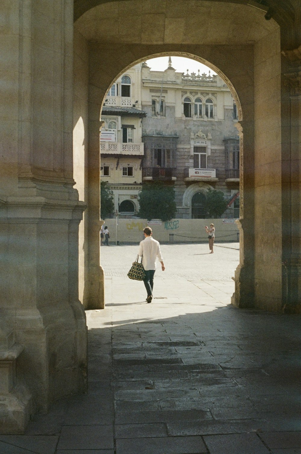 a man walking through an archway in a building