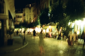 A bustling city street at dusk with warm lights glowing from cozy cafes.