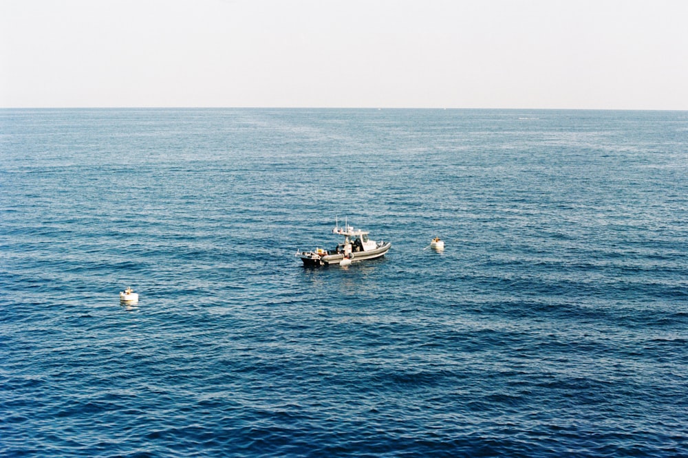 a small boat floating on top of a large body of water