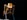 a yellow and black robot standing in the dark