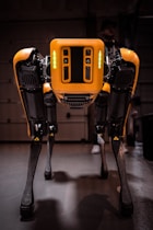 a yellow and black robot standing in a garage