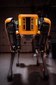 a yellow and black robot standing in a garage