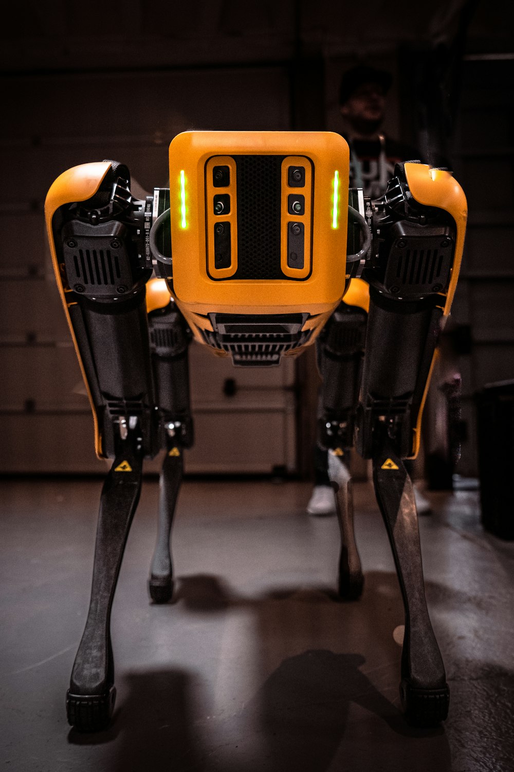 a yellow and black robot standing in a garage