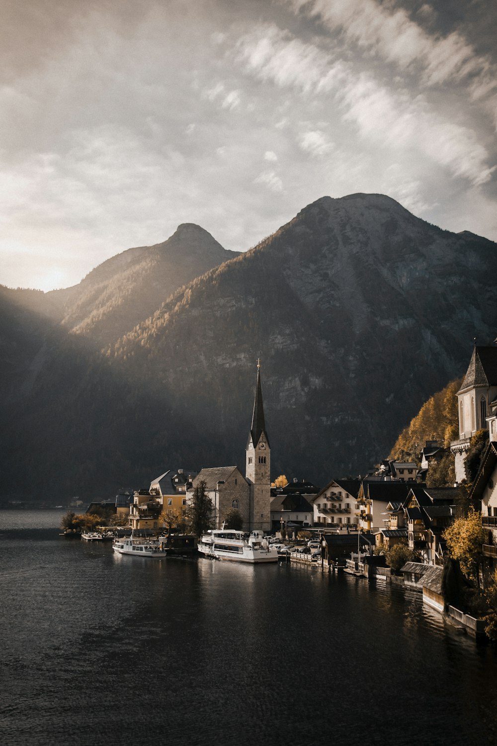 uma pequena cidade em um lago com montanhas ao fundo