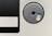 A close-up of a vintage floppy disk, showcasing the circular metal shutter and a portion of the black magnetic disk area.