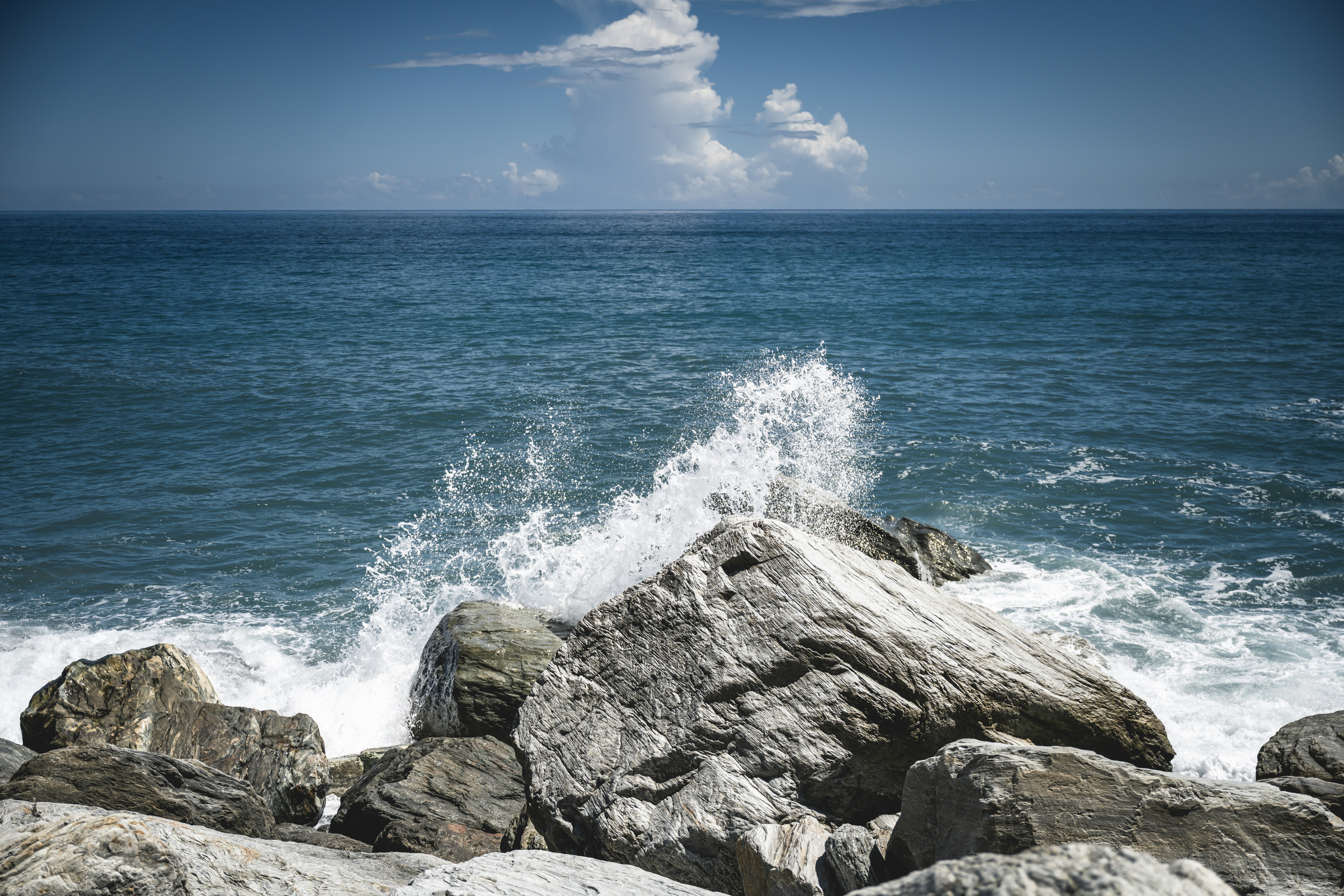 a large body of water sitting next to a rocky shore