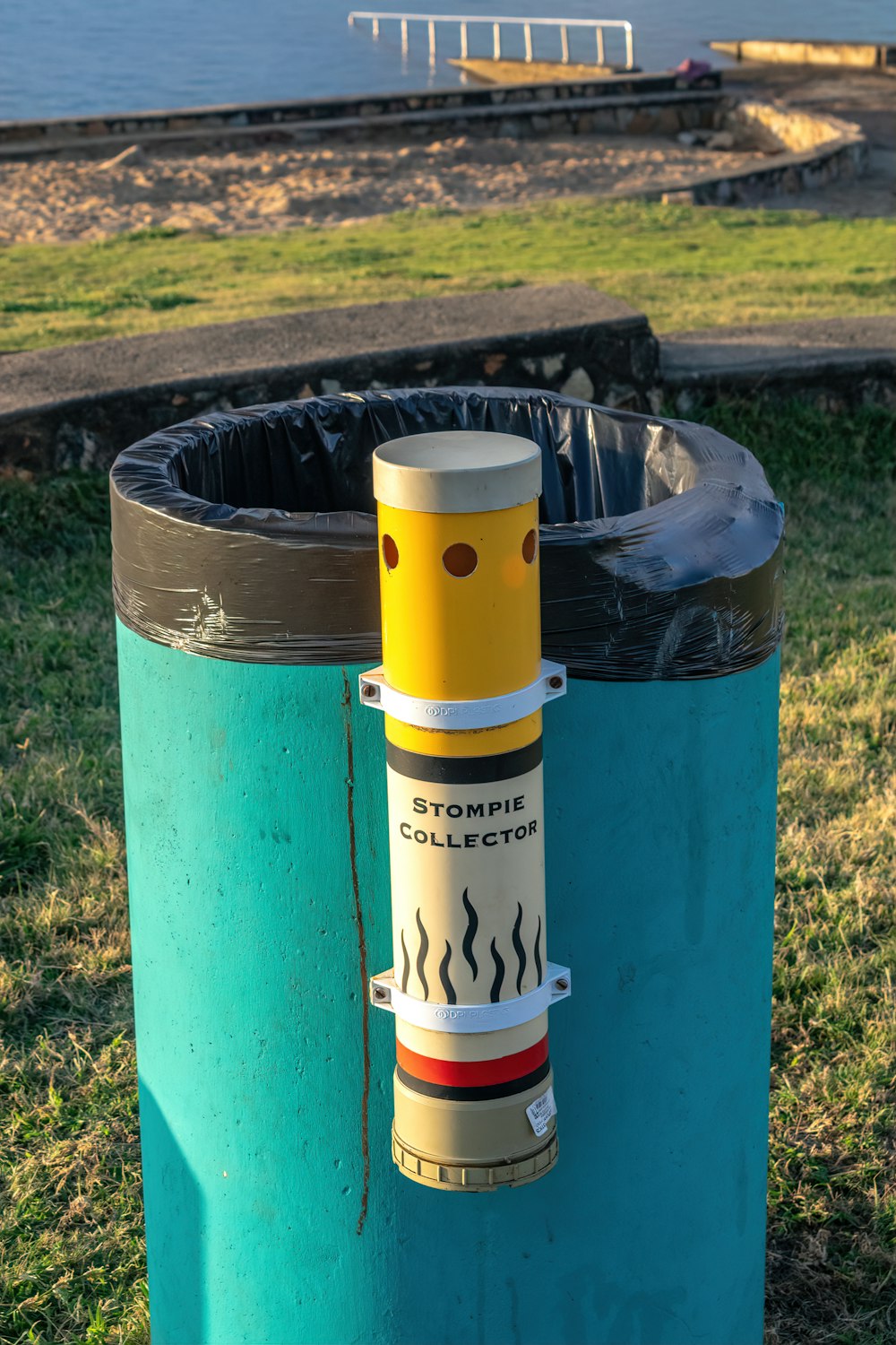 a blue trash can with a yellow tube sticking out of it