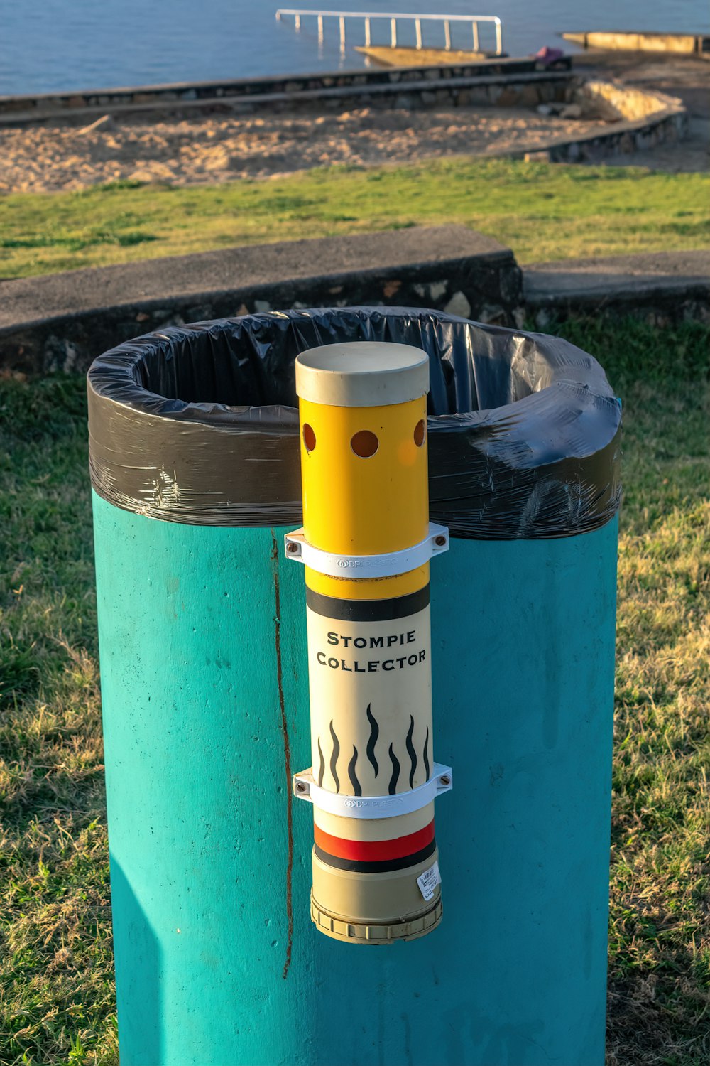 une poubelle bleue avec un tube jaune qui en sort