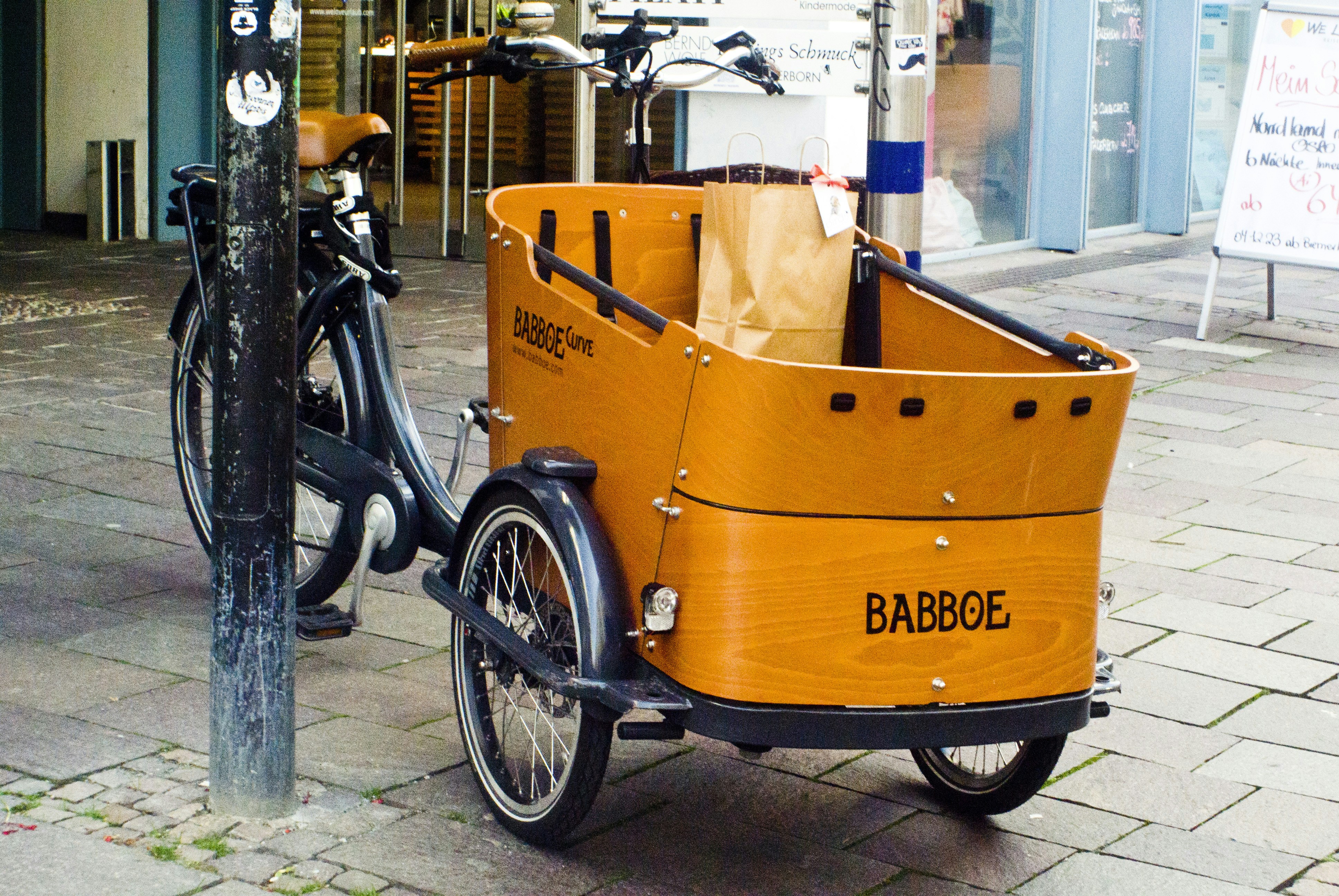 a bike with a basket attached to it parked next to a pole