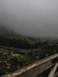 A misty morning over the lush green hills and ancient stone walls of the Irish countryside.