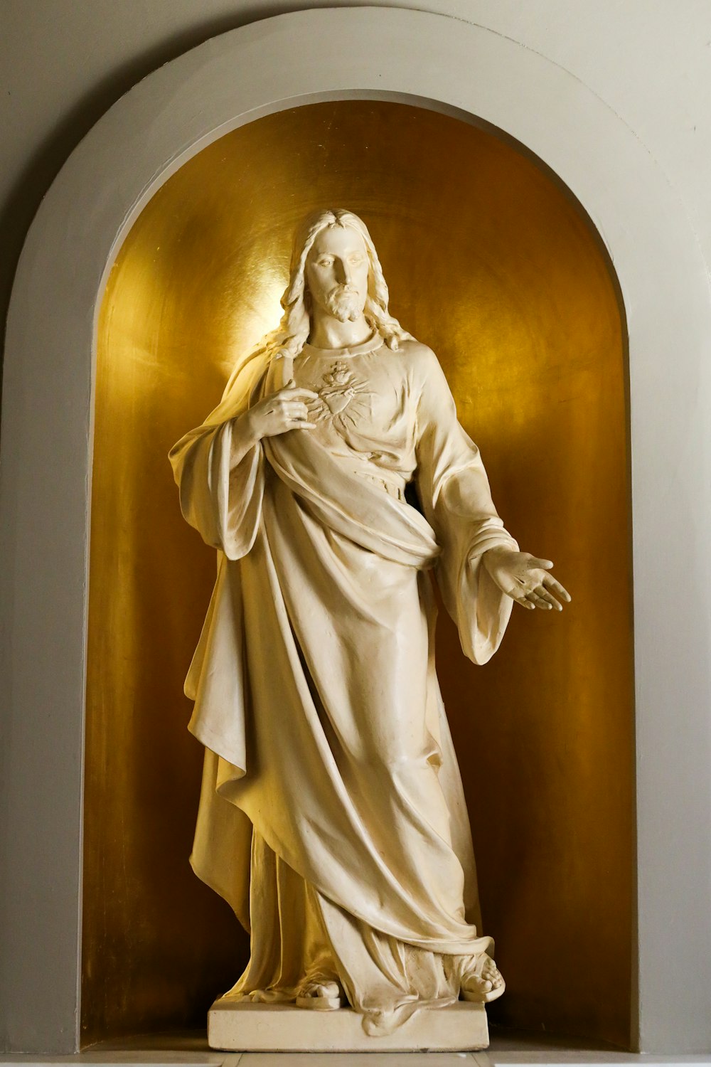a statue of jesus holding his hands out