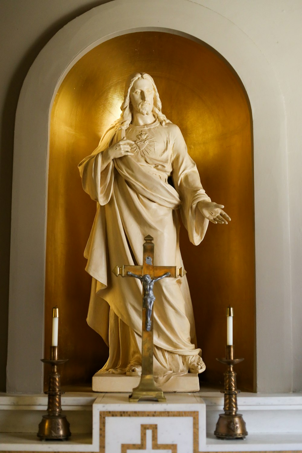 a statue of jesus holding a cross in a church